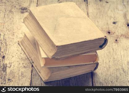 Old books on wooden background in vintage tone color