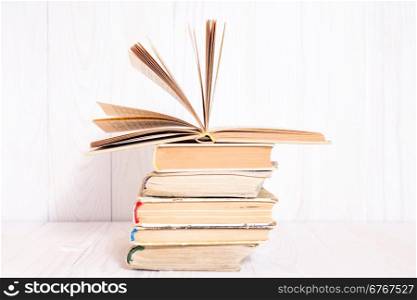Old books stacked on white wooden background, knowledge concept
