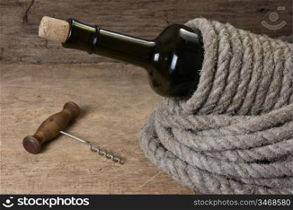Old bottle of wine and corkscrew on the board