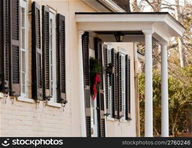 Old brick colonial house decorated for Christmas with wreath on door