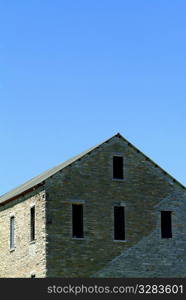 Old brick house under a blue sky.