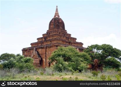 Old brick temple, trees and bush in Bagan, Myanmar