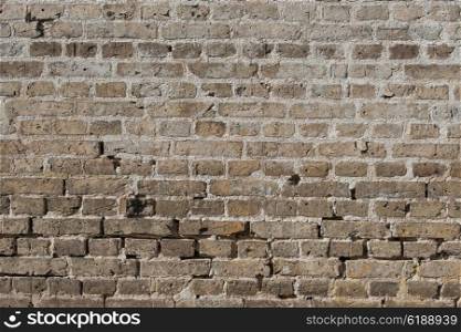 Old brick wall with worn stones and dark colors