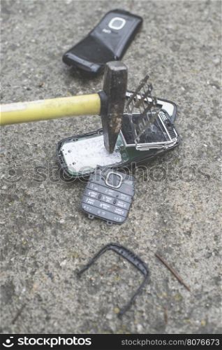 Old broken mobile phone. Hammer crease phone