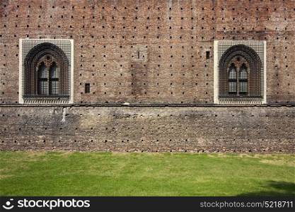 old brown castle brick and window in the grass of castle sforzesco milan