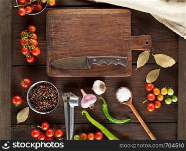 old brown empty kitchen cutting and fresh red cherry tomatoes with green chili peppers on the table, top view