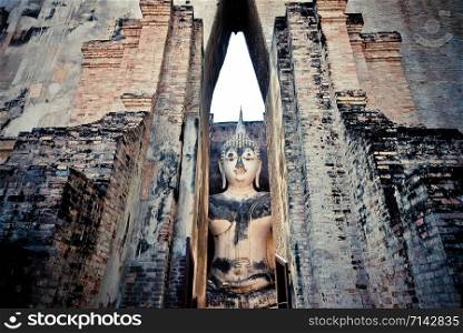 Old buddha statue on wall in ancient temple thailand Sukhothai historical park