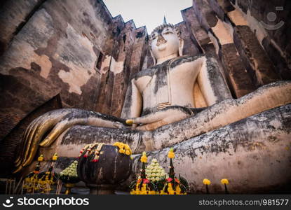 Old buddha statue on wall in ancient temple thailand Sukhothai historical park