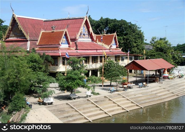 Old buddhist temple on the bank of river in Lop Buri, Thailand