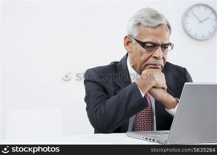 Old businessman looking at a laptop