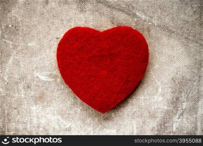 Old canvas background with a small red heart