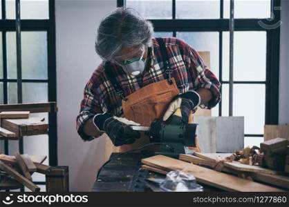 old carpenter man working in carpenter studio