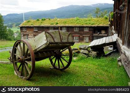Old cart and wooden barns in farm in Norway