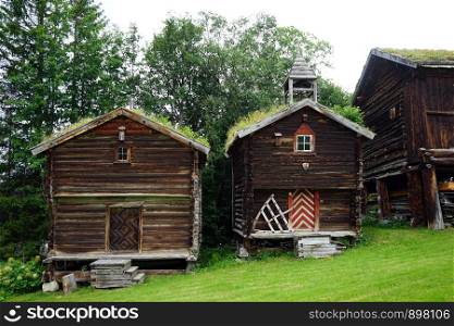 Old cart and wooden barns in farm in Norway