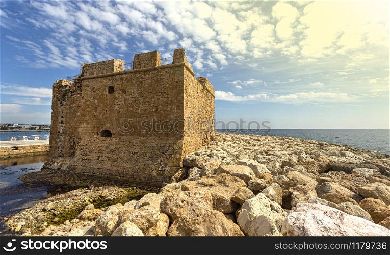 Old castle on Mediterranean sea coast. Paphos, Cyprus. Bright sunset light