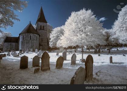 Old church in English countryside landscape in infrared