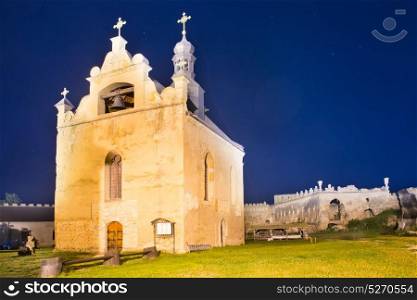 Old church in medieval castle at night under dark blue sky with many stars