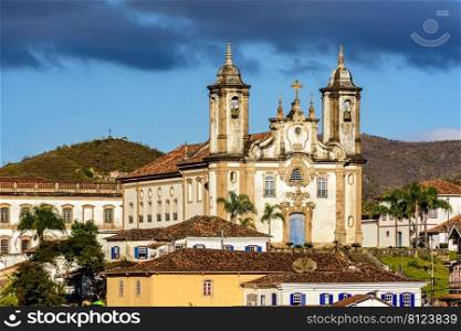 Old churches on top of the hill and between the houses in the city of Ouro Preto in Minas Gerais during the late afternoon. Old churches on top of the hill and between the houses in the city of Ouro