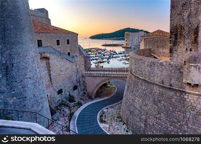 Old city walls and Old Harbour of Dubrovnik at sunset in Dubrovnik, Croatia. Old Harbor of Dubrovnik, Croatia