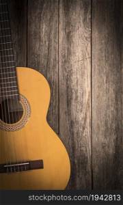 Old classic guitar on a wooden background