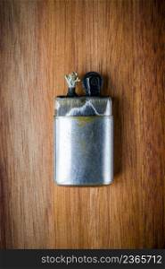 Old classic vintage lighter on a wooden background. Old vintage lighter on a wooden background