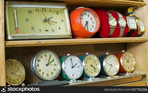 Old clocks on a shelf in shop
