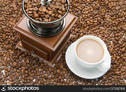 Old coffee grinder and a cup of coffee