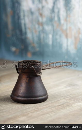 Old coffee pot on blue rustic background