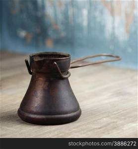 Old coffee pot on blue rustic background
