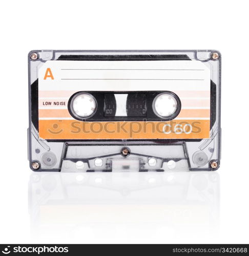 Old compact cassette audio tape isolated on white with natural shadow.