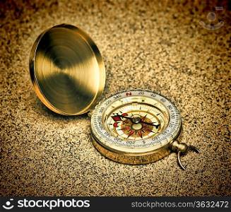 Old compass on a sandy beach