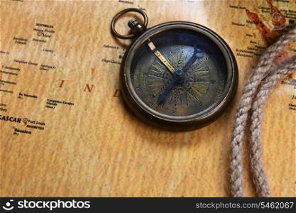 old compass on vintage map and rope