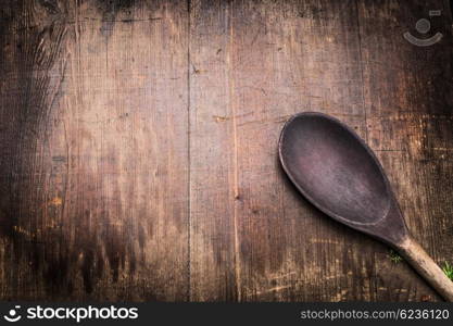 Old cooking spoon on aged wooden background, top view. Food and cooking background for menu or recipes, top view