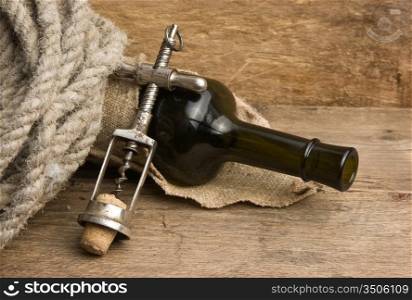 Old corkscrew and bottle of wine on the board