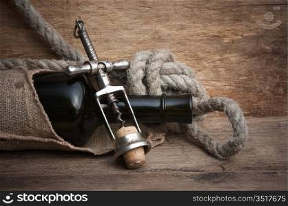 Old corkscrew and bottle of wine on the board