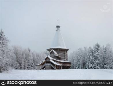 Old country wooden church of St. George (1672) in the northern open air museum Malye Korely near Arkhanglesk, Russia. Snowy winter day.