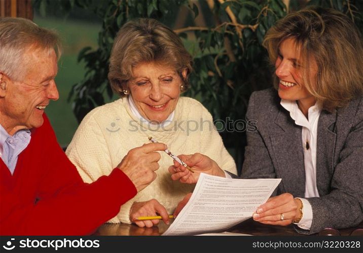 Old Couple Signing Papers With Young Executor