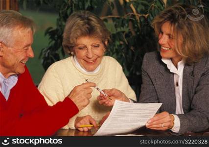 Old Couple Signing Papers With Young Executor