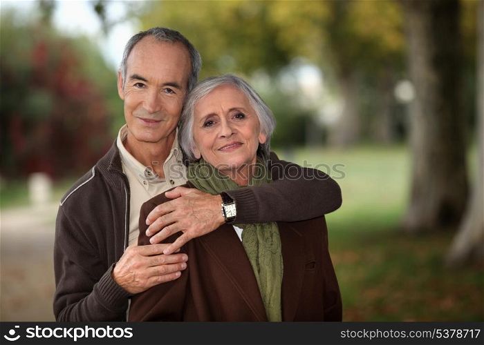 Old couple walking through park