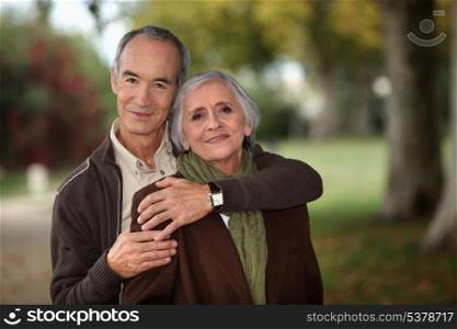 Old couple walking through park