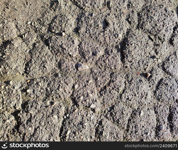 Old cracked asphalt, with dirt and small stones