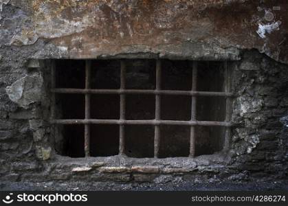 Old creepy cellar window with bars.