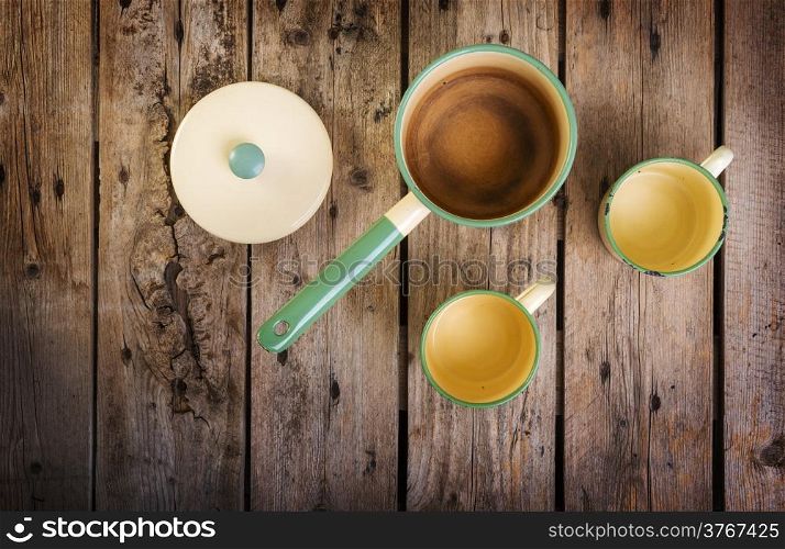 Old cups and saucepan in a retro kitchen table setting