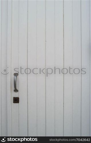 Old decayed white wooden closed door exterior.