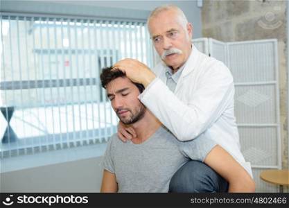 old doctor checking a patient with head problem