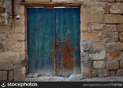 Old door in stony fence. Horizontal photo