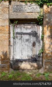 Old doorway to Cotswold manor house garden, Warwickshire, England.