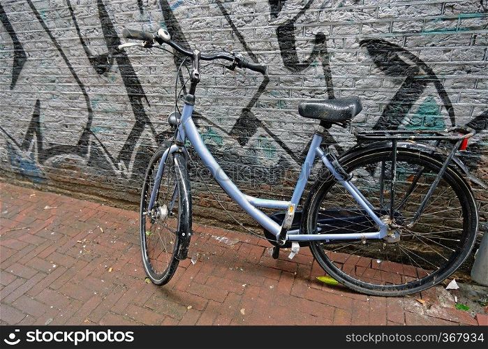 Old dutch bike against a graffiti wall in Amsterdam Netherlands