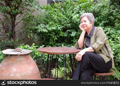 old elder woman resting in park. asian elderly female relaxing outdoors. senior leisure lifestyle