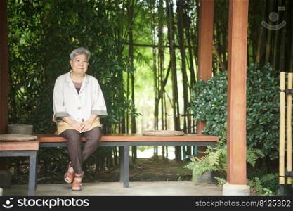 old elderly elder senior woman resting relaxing sitting in garden